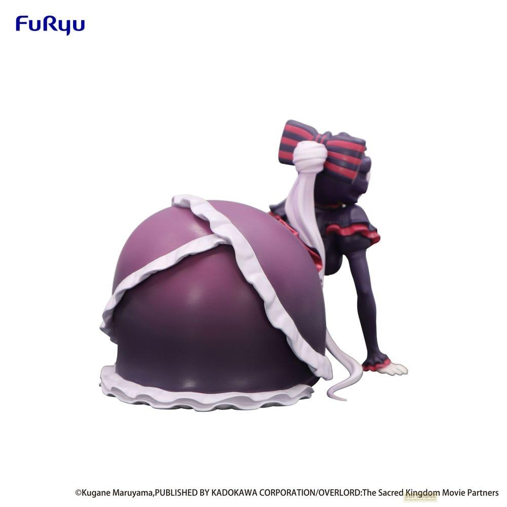 Eine Figur mit lila Kleid, rotem Schleifen-Haarband und weißen Akzenten.