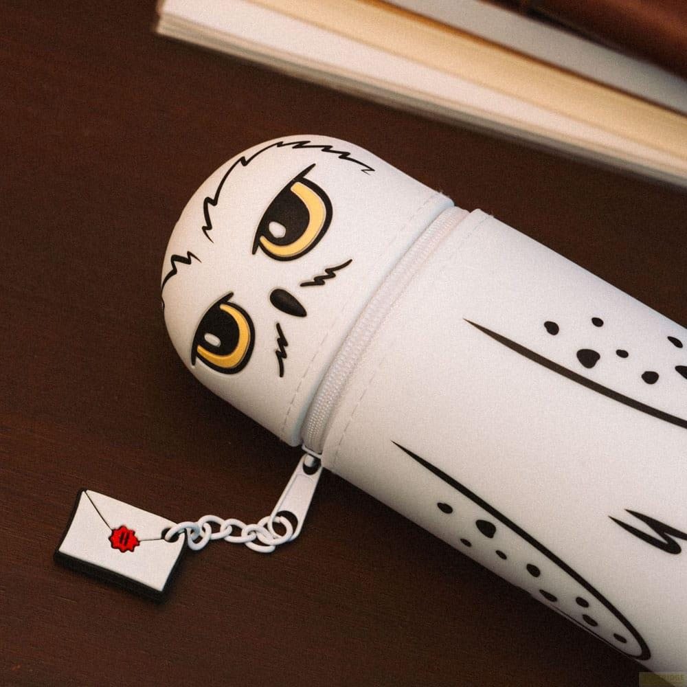 Un estuche blanco con diseño de búho y un amuleto de carta.