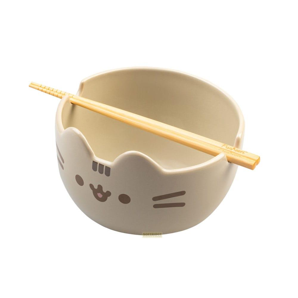 Un cuenco beige con diseño de gato Pusheen y palillos encima.