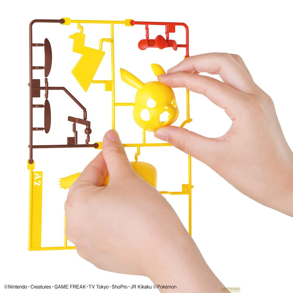 Des mains assemblent un modèle jaune de Pikachu à partir de pièces en plastique.
