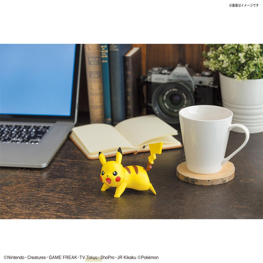 Figurine Pikachu sur un bureau à côté d'un ordinateur portable, d'un livre et d'une tasse.