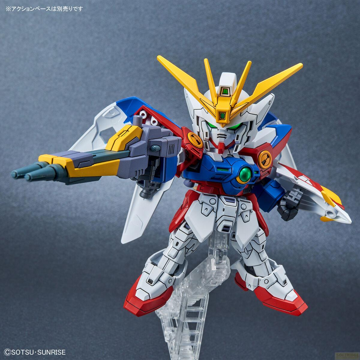 Un robot Gundam coloré blanc, rouge, bleu et jaune avec un pistolet.