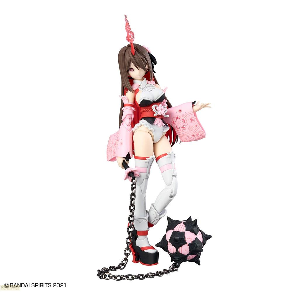 Figurine d'anime aux cheveux bruns, cape rouge, manches roses et arme fléau.