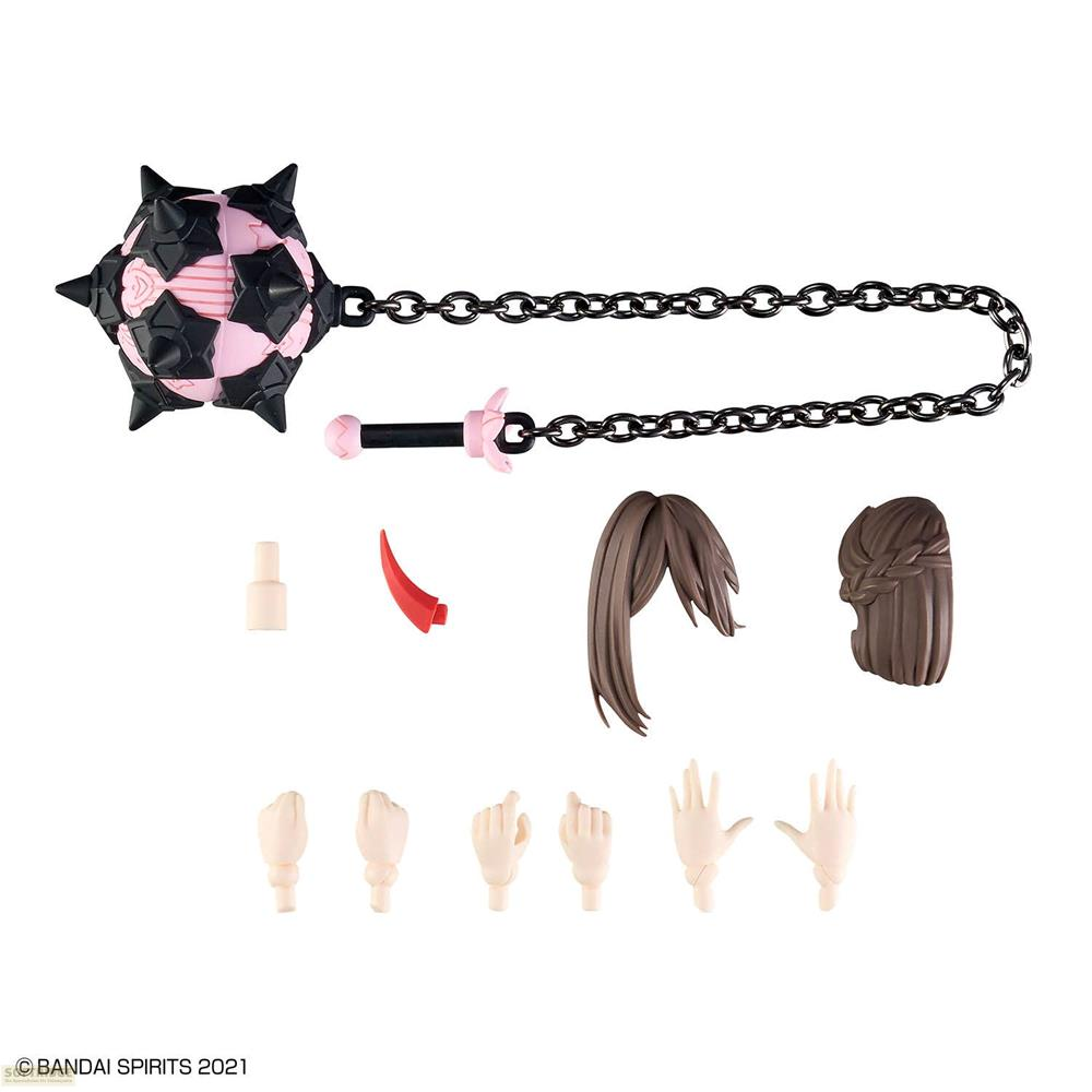 Objet à pointes rose et noir avec chaîne, manche, cornes rouges, cheveux et mains.
