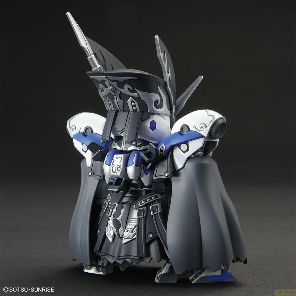 Petite figurine robot avec corps noir et blanc, accents bleus et cape grise.