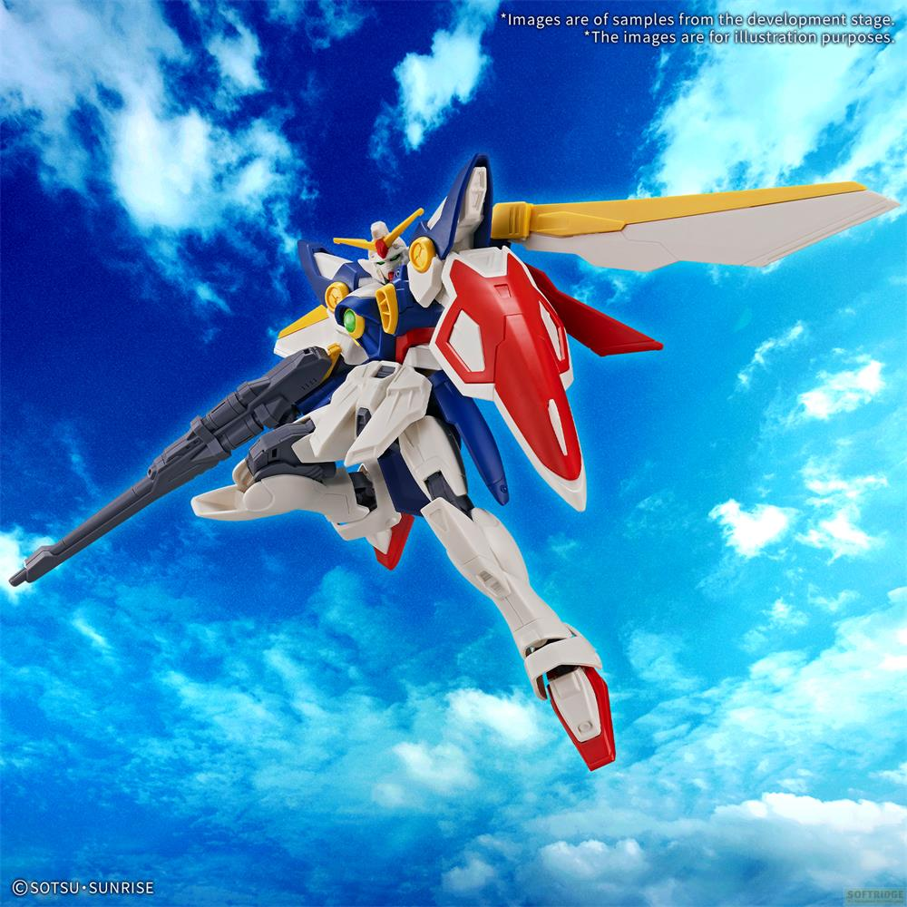Un mécha blanc, bleu et rouge tenant un fusil devant un ciel bleu et nuageux.