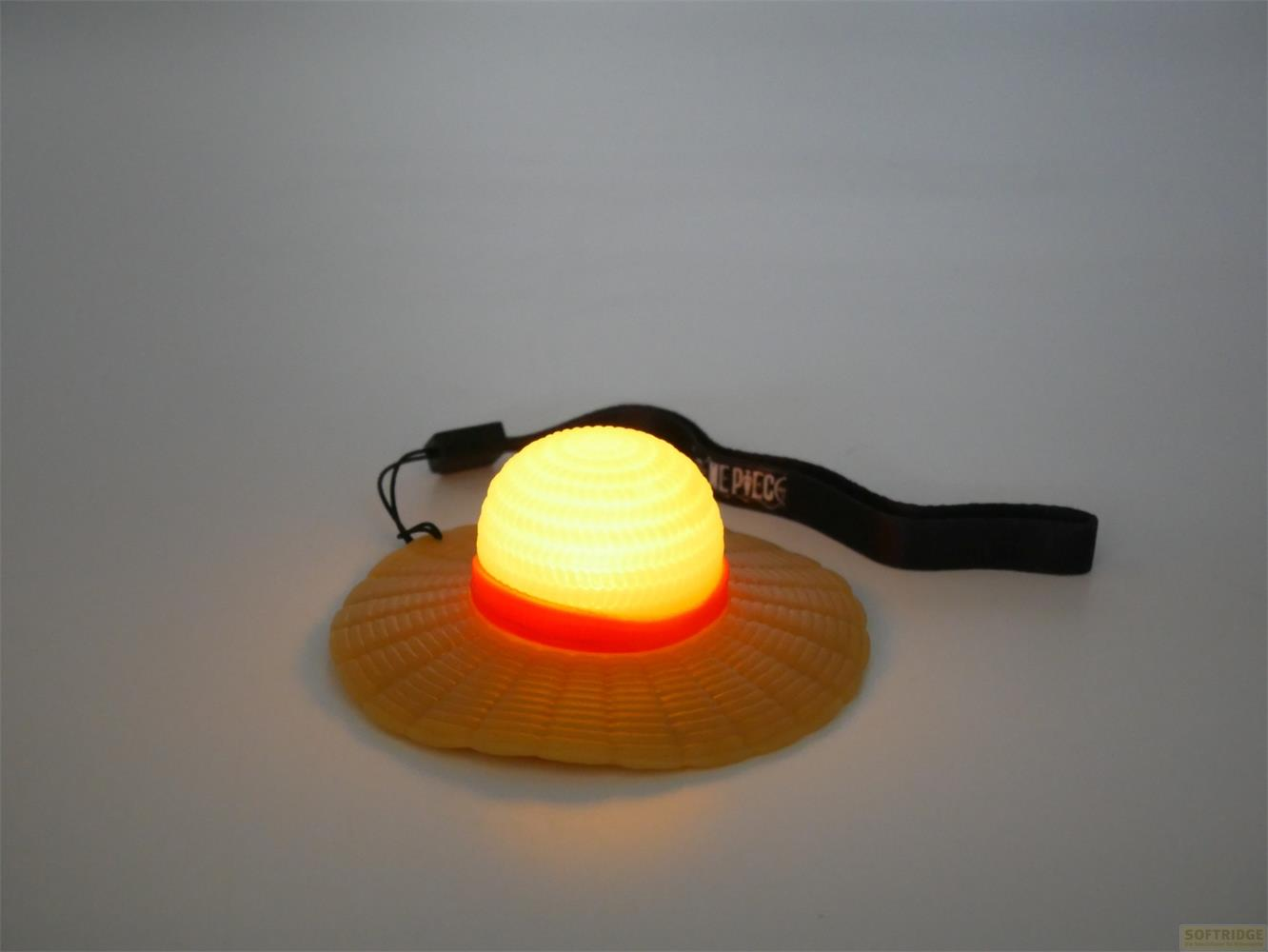 Un chapeau de paille jaune avec bande orange et dôme lumineux.