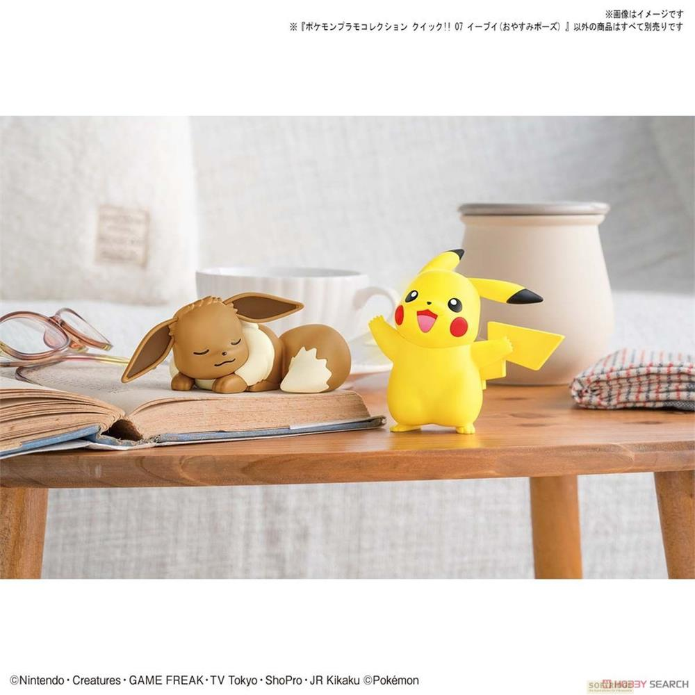 Pikachu und Evoli Figuren auf einem Holztisch, Evoli schläft, Pikachu steht.