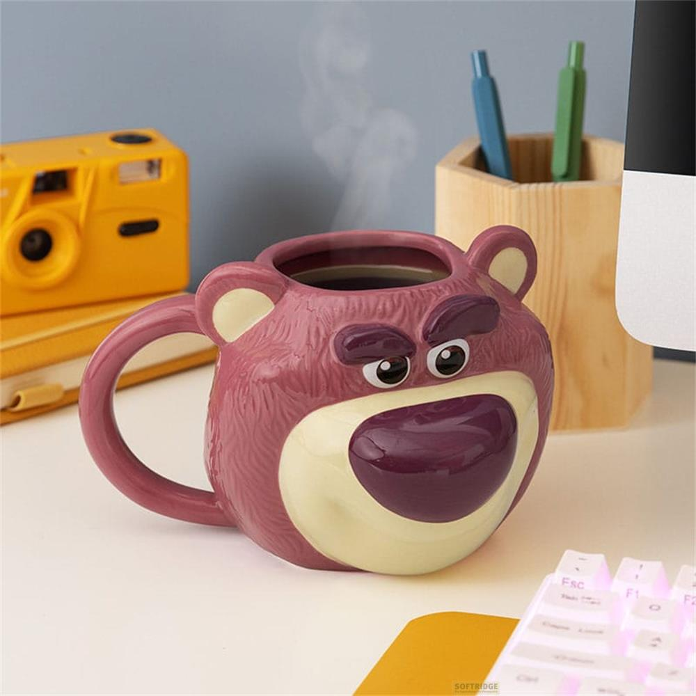 Una taza rosa de Lotso con vapor ascendente está sobre un escritorio.