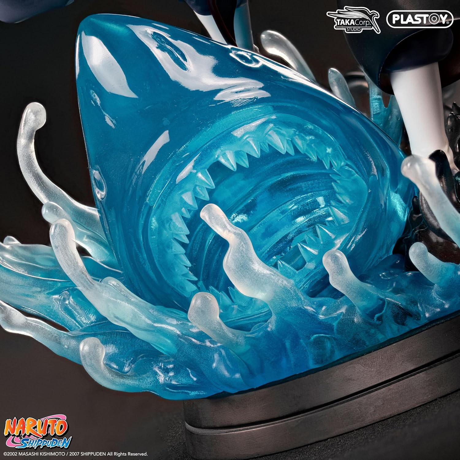 Nahaufnahme eines blauen, durchscheinenden Haikopfes mit scharfen Zähnen, umgeben von klaren Wasserspritzern auf schwarzem Sockel.