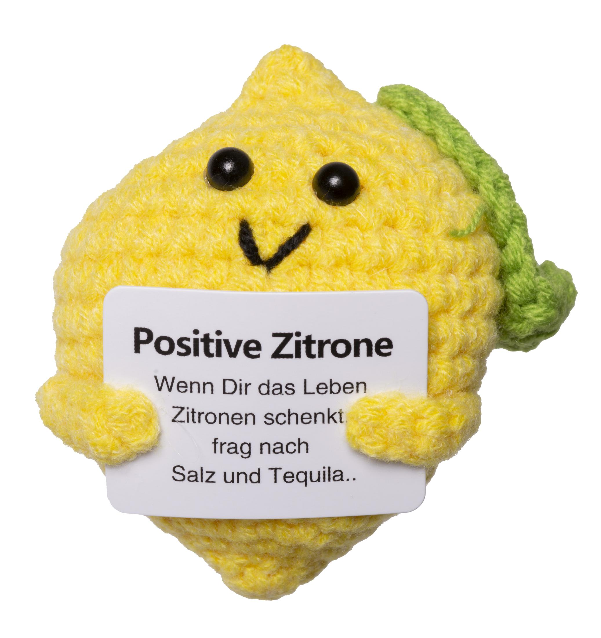 Figurine citron jaune au crochet avec un visage noir et une pancarte.
