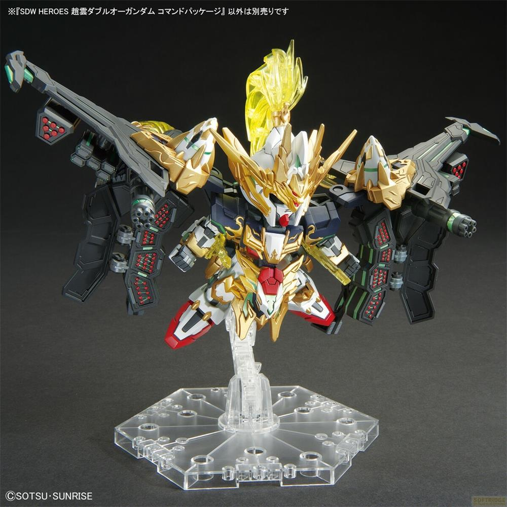 Ein goldener und weißer Roboter mit Flügeln und Waffen auf einem Ständer.