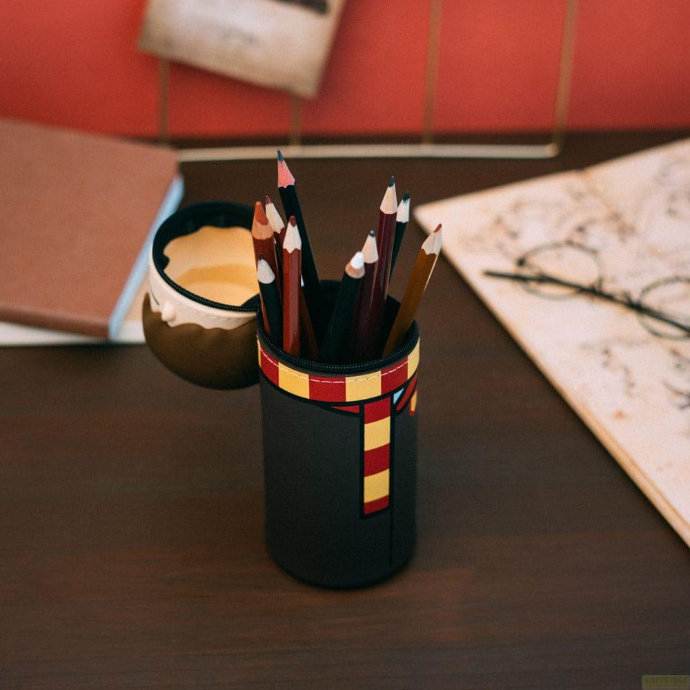 Un portalápices con diseño de bufanda de Harry Potter, lleno de lápices de colores.
