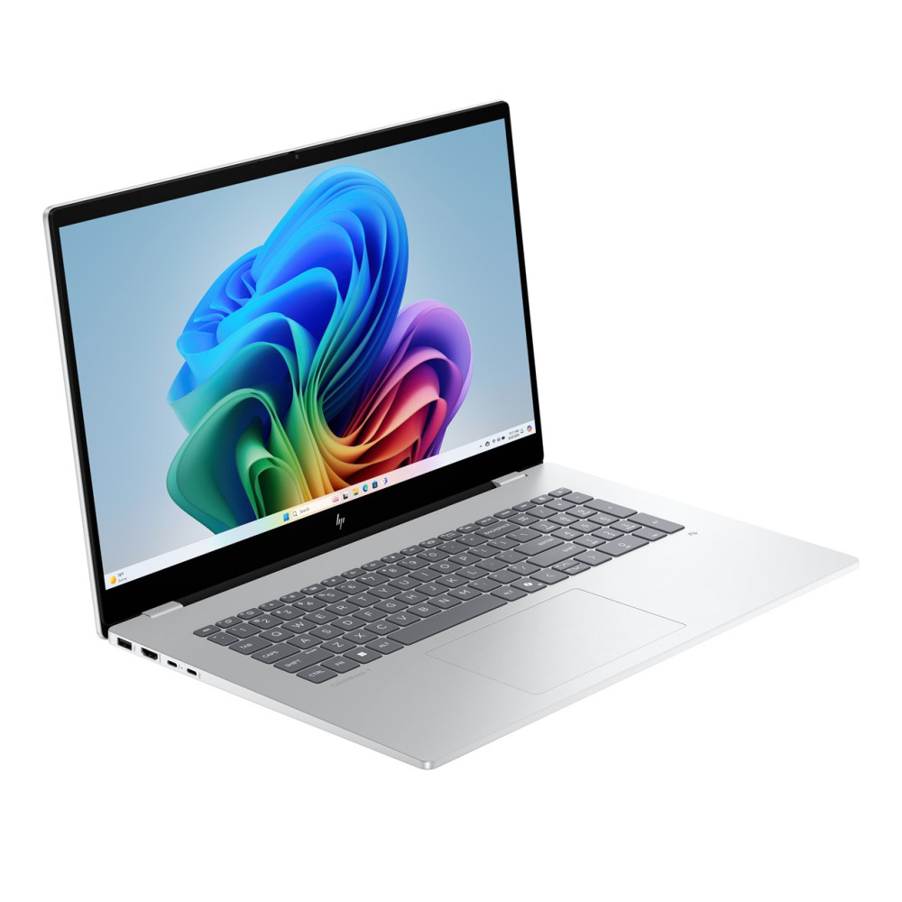 Srebrny laptop z kolorową tapetą na ekranie.