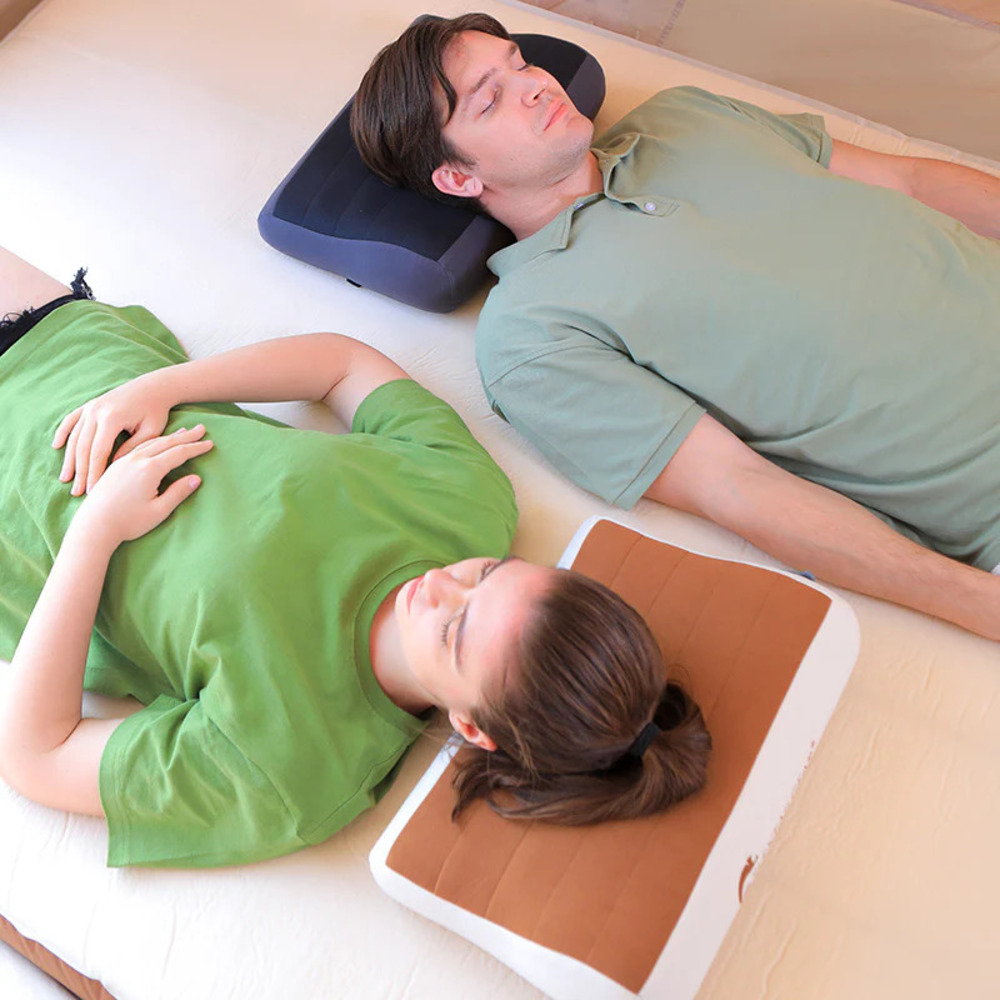 Ein Mann und eine Frau liegen auf dem Rücken auf einem Bett, beide schlafen.
