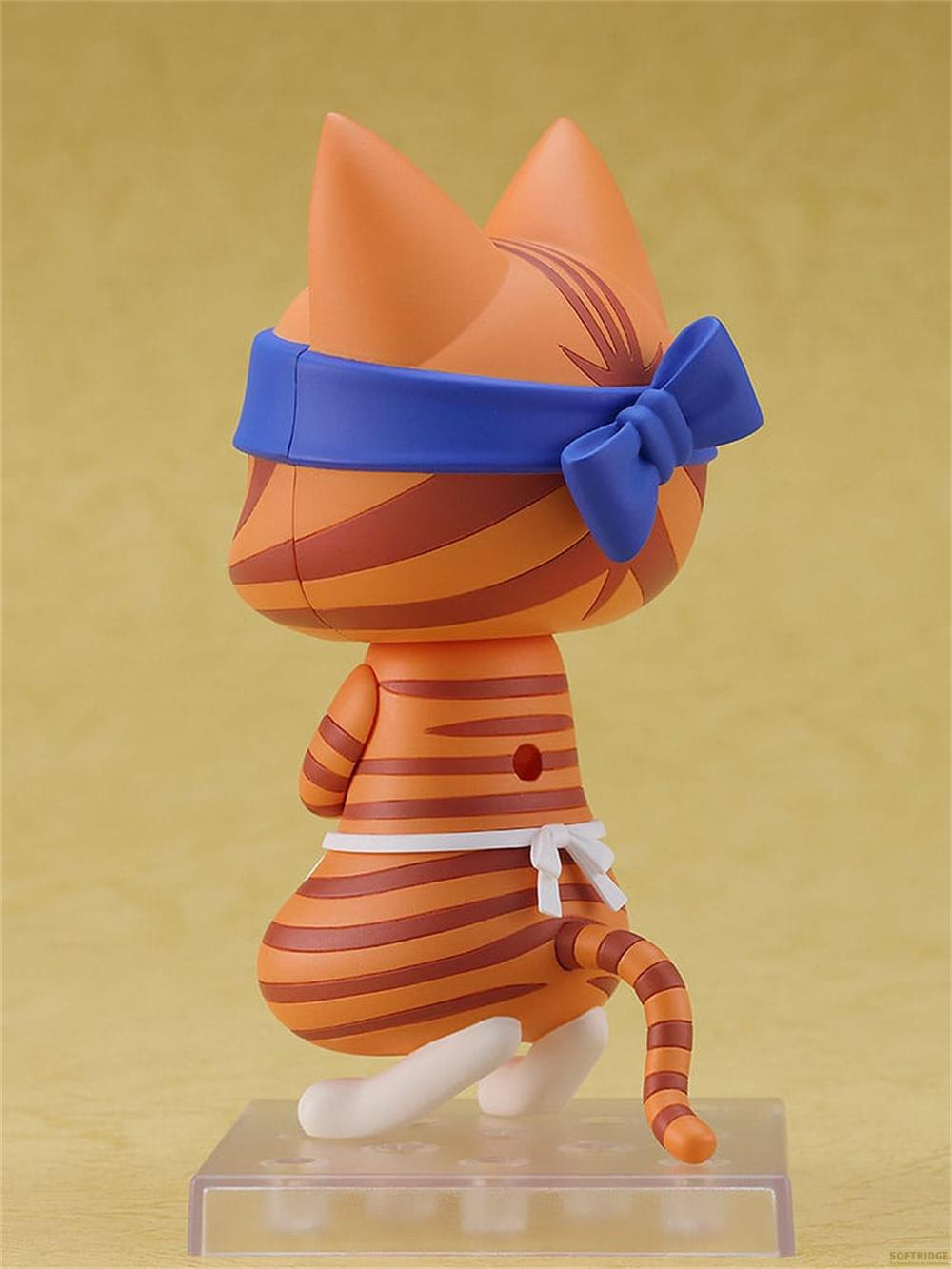 Eine orangefarbene Katze mit braunen Streifen, die eine blaue Bandana und eine weiße Schürze trägt.