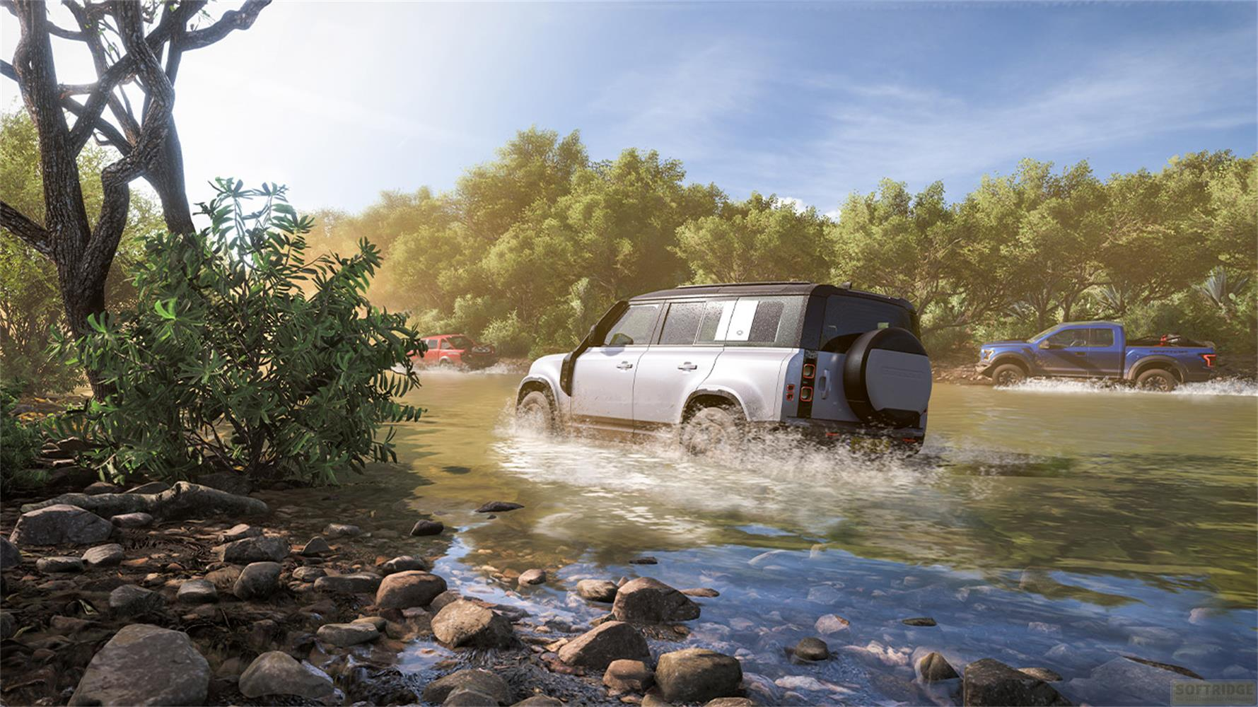 Zwei Geländewagen fahren durch einen Fluss, umgeben von Bäumen.