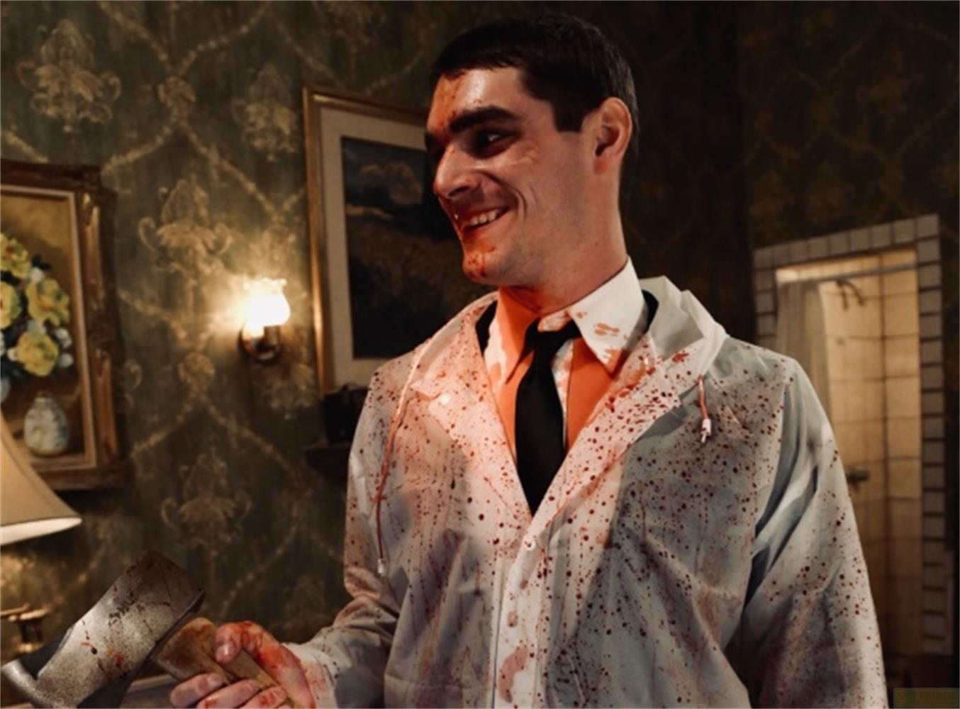 Uomo con camice macchiato di sangue e ascia sorride.