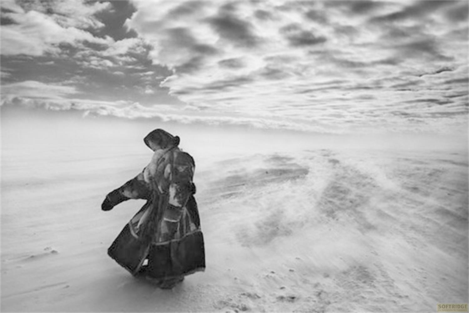 Una persona con abiti pesanti sta in un paesaggio innevato.