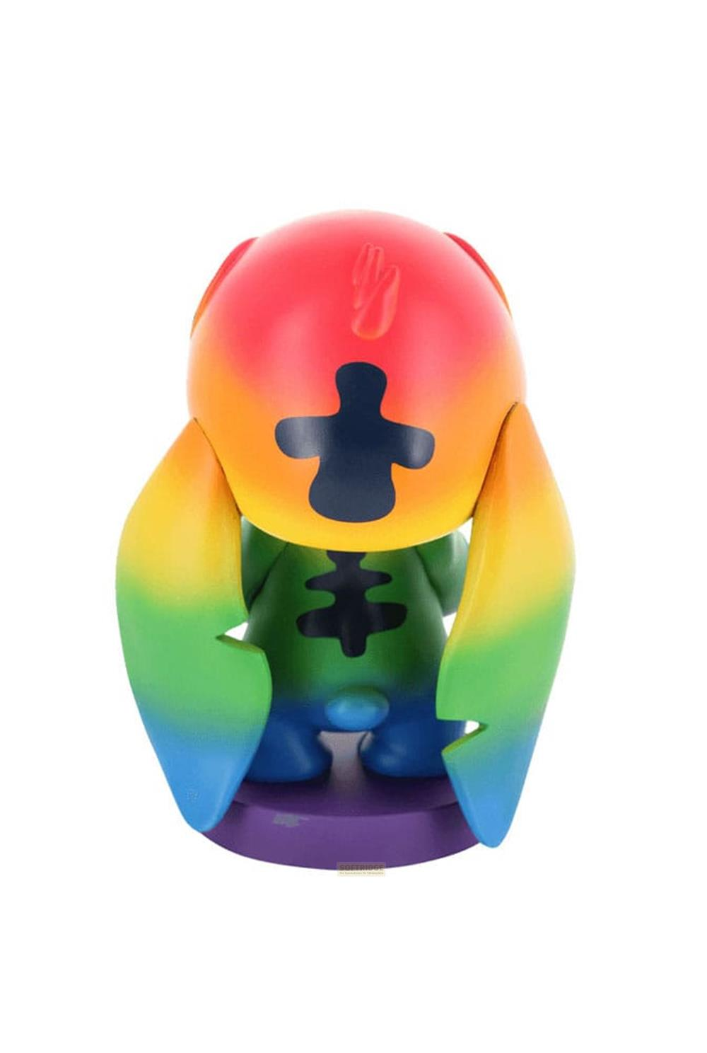 Un giocattolo con colori arcobaleno sulla testa e sulle braccia, corpo verde e base viola.