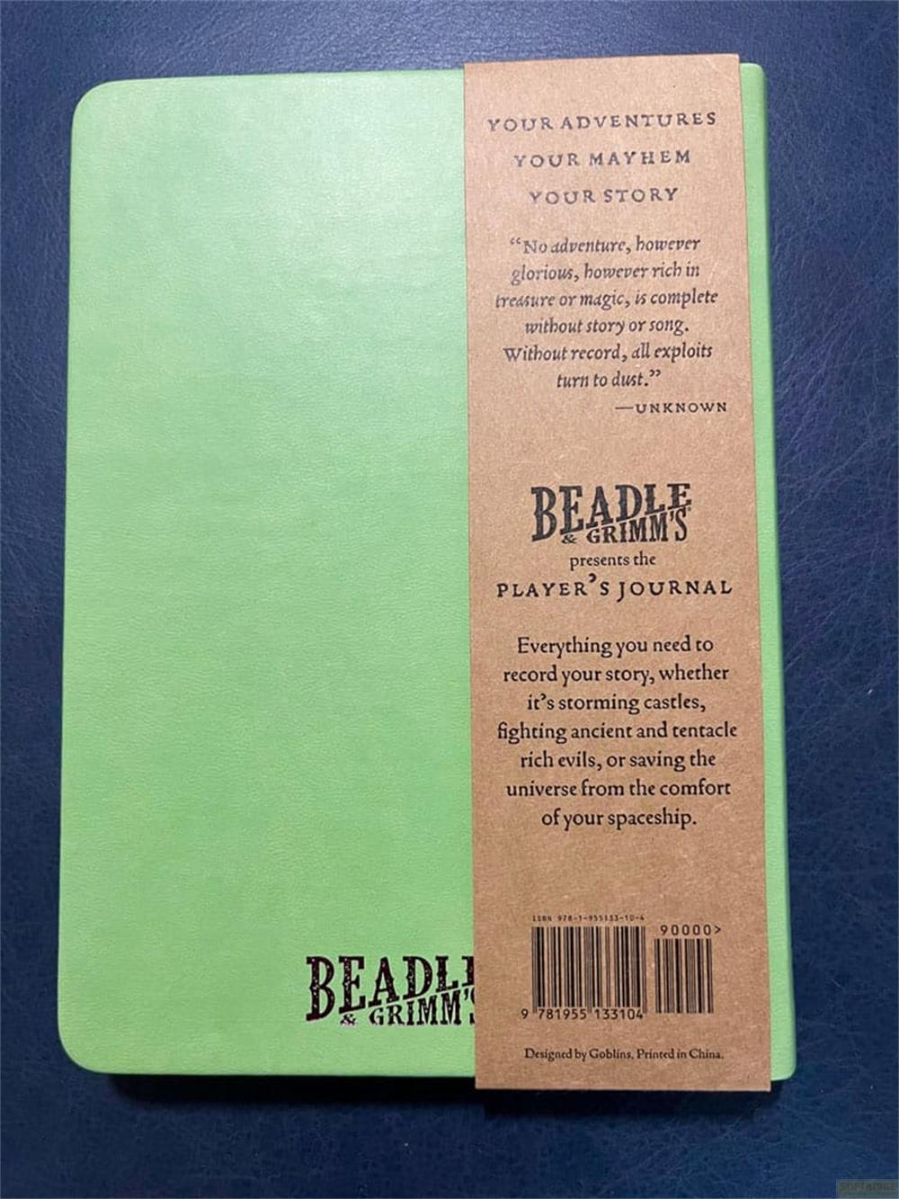 Un carnet vert avec une étiquette marron faisant la publicité d'un journal de joueur.