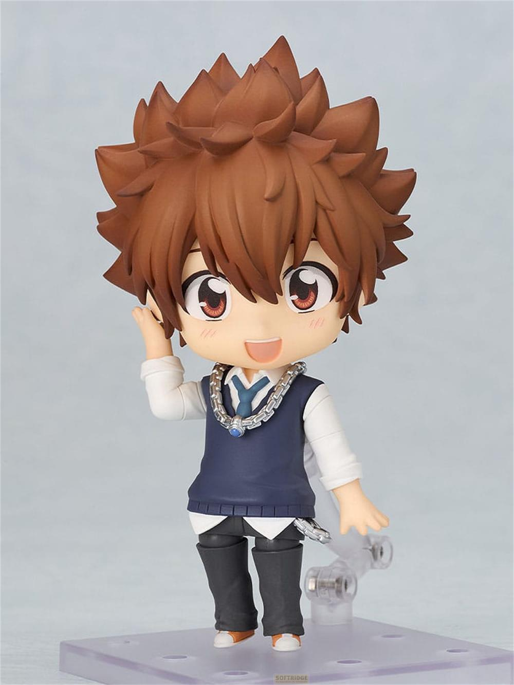 Una figura anime con capelli castani, gilet blu e collana.
