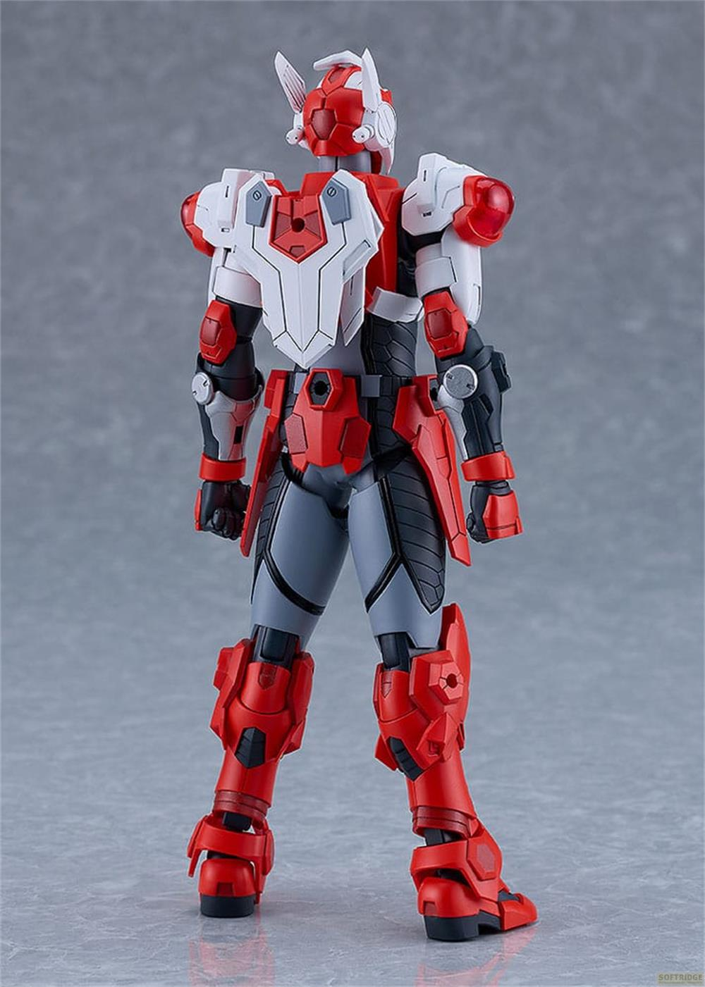 Un robot rouge et blanc se tient de profil sur fond gris.