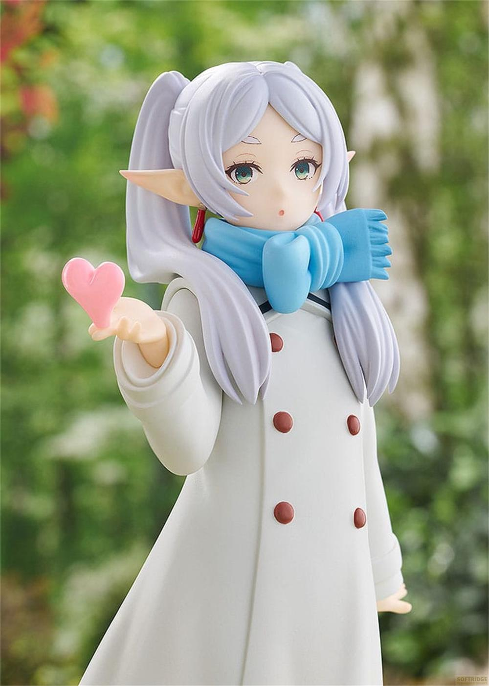Figura de anime con pelo blanco, bufanda azul, abrigo blanco, sosteniendo un corazón rosa.