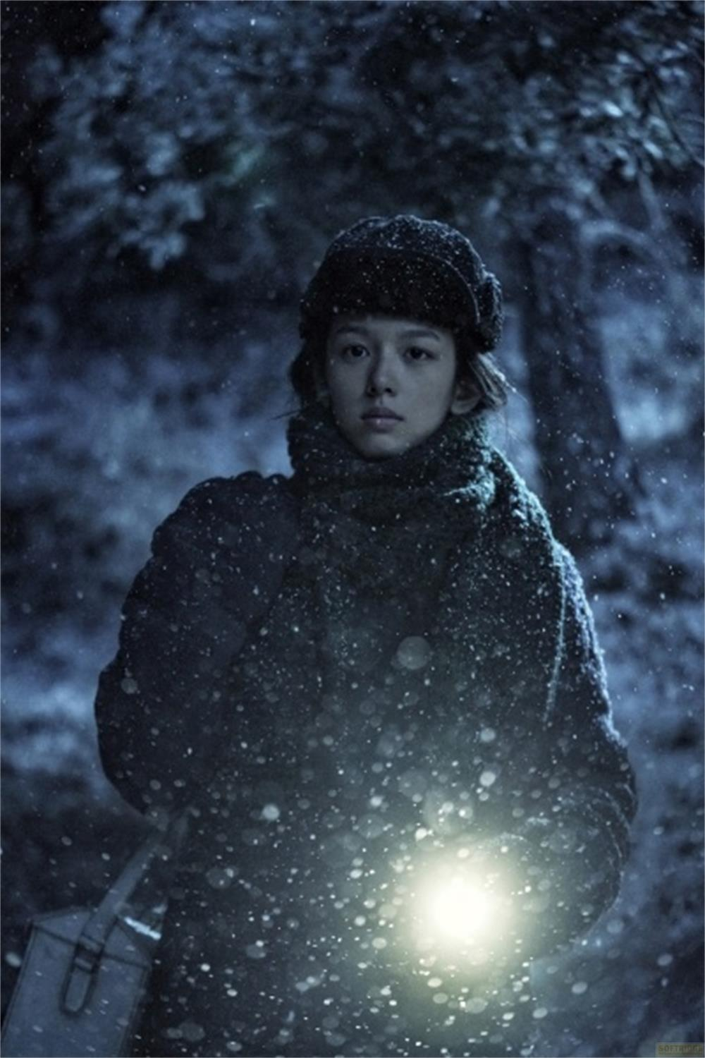 Una ragazza nella neve con una lanterna in mano.