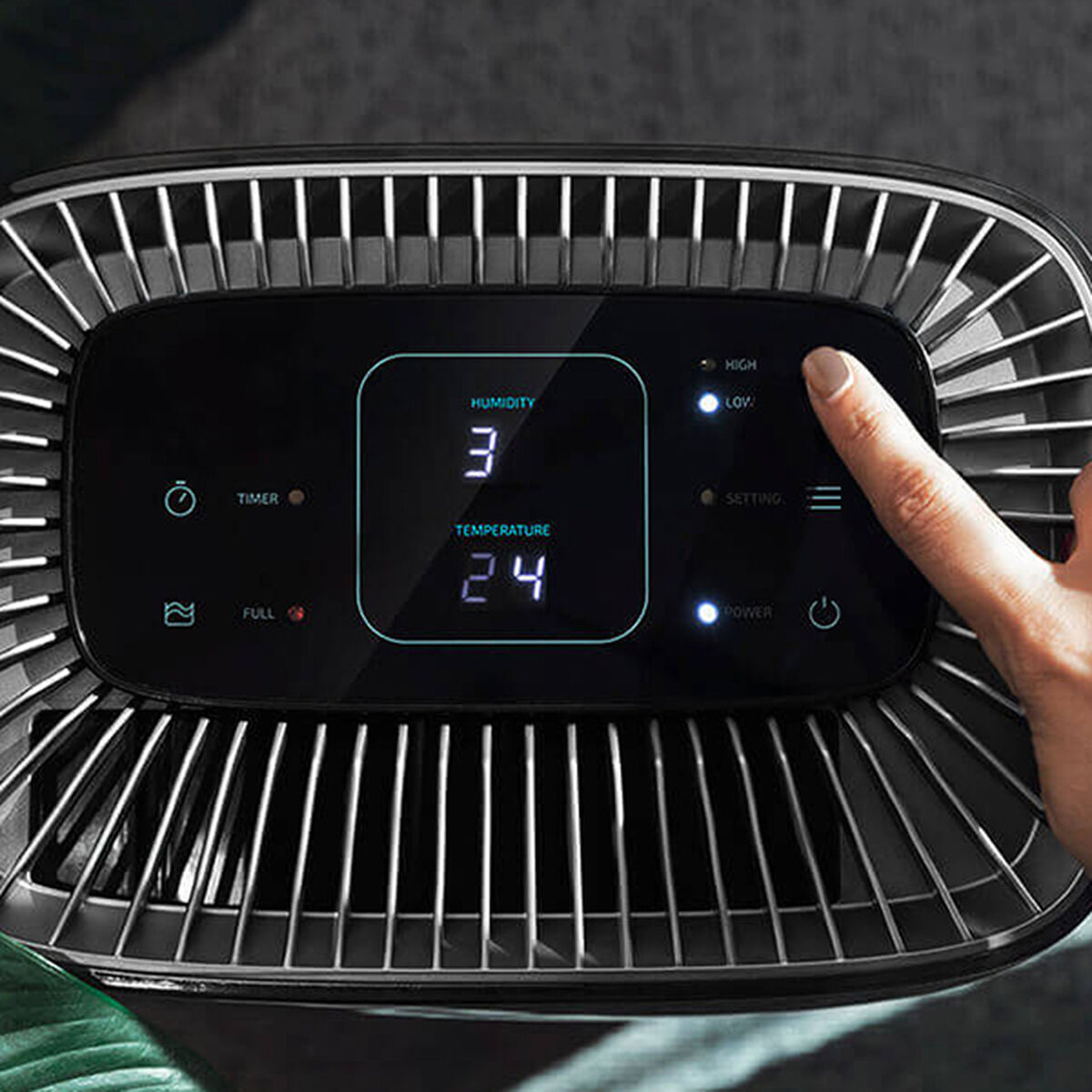 Ręka dotyka wyświetlacza pokazującego wilgotność 3 i temperaturę 24.