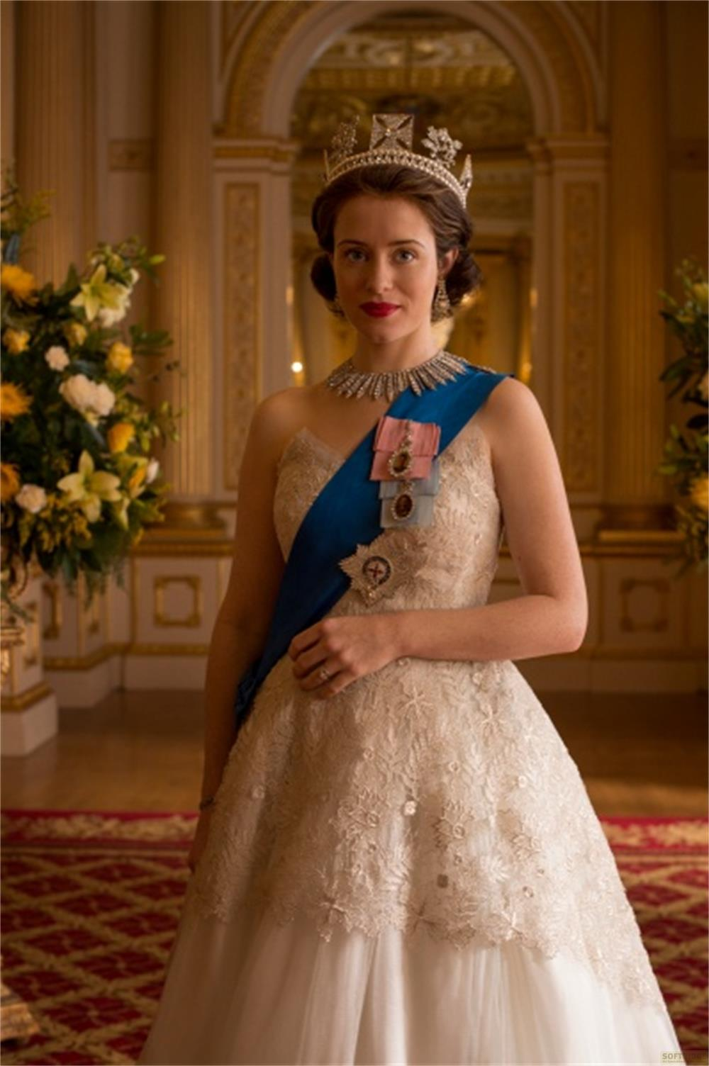 Una donna in abito da incoronazione con tiara e fascia blu.
