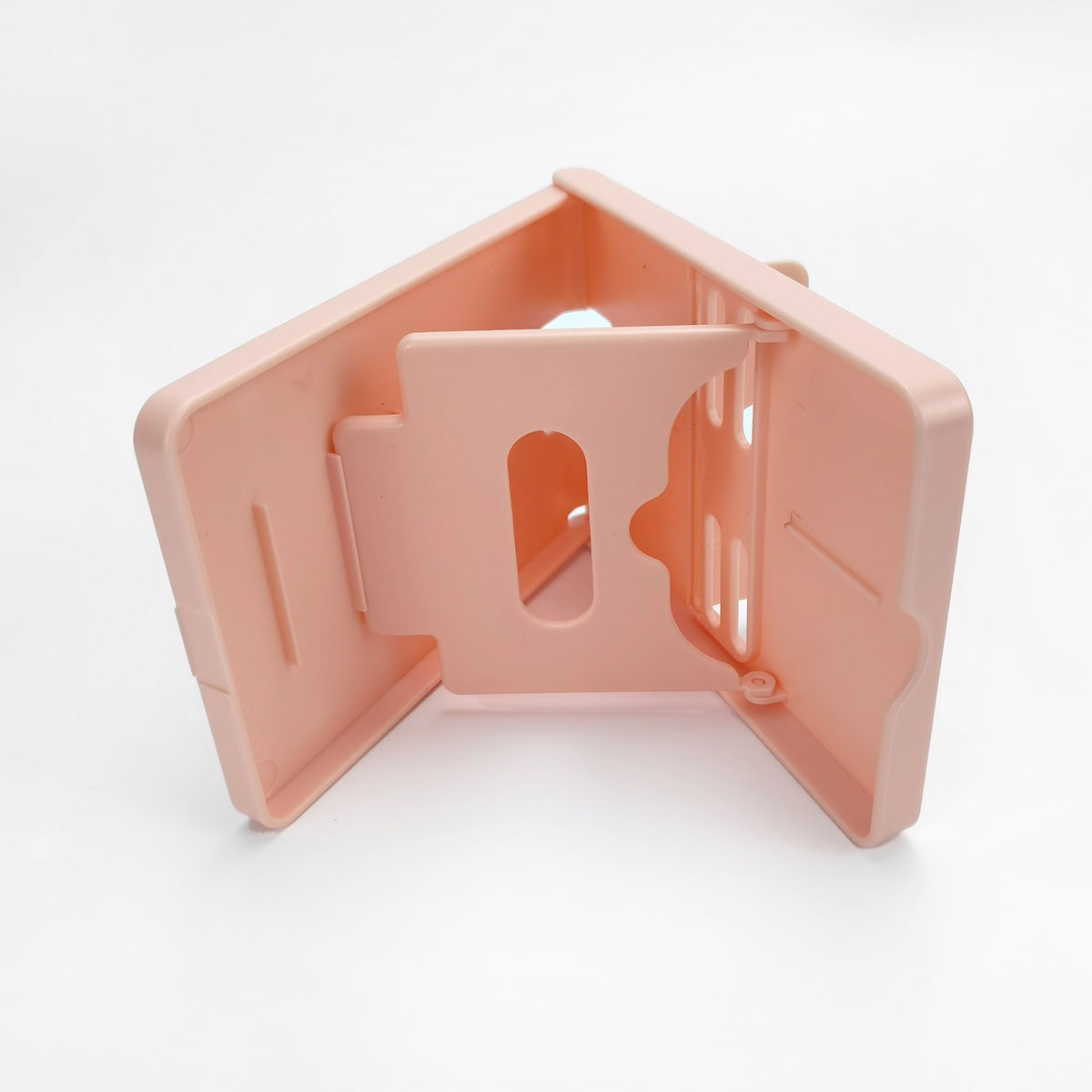 Een roze, driehoekige plastic standaard met sleuven.