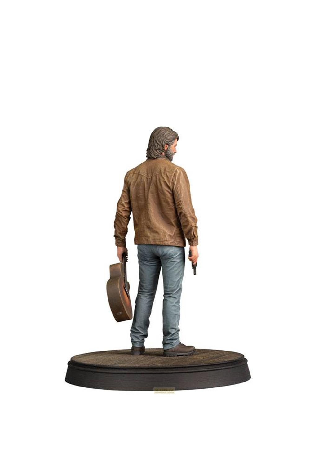 Hombre con guitarra y pistola sobre base.