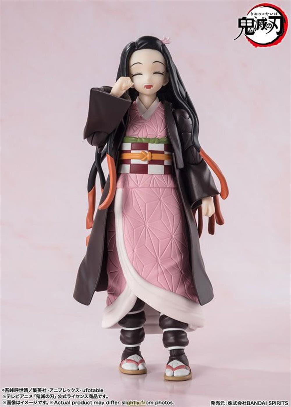 Una figura di Nezuko Kamado in abito rosa e cappotto scuro.
