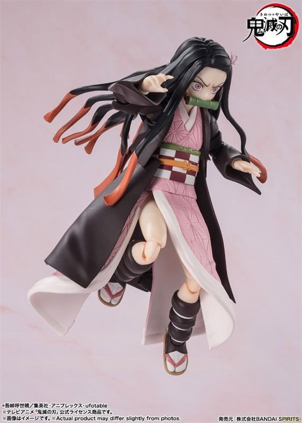 Una figura anime con capelli neri, kimono rosa, cappotto scuro e bambù in bocca.