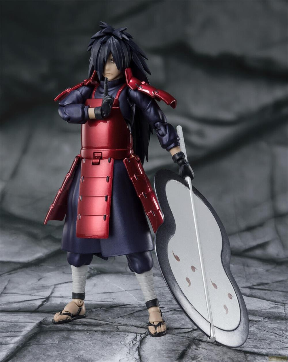 Statua di Madara Uchiha in armatura con scudo e spada su sfondo grigio.