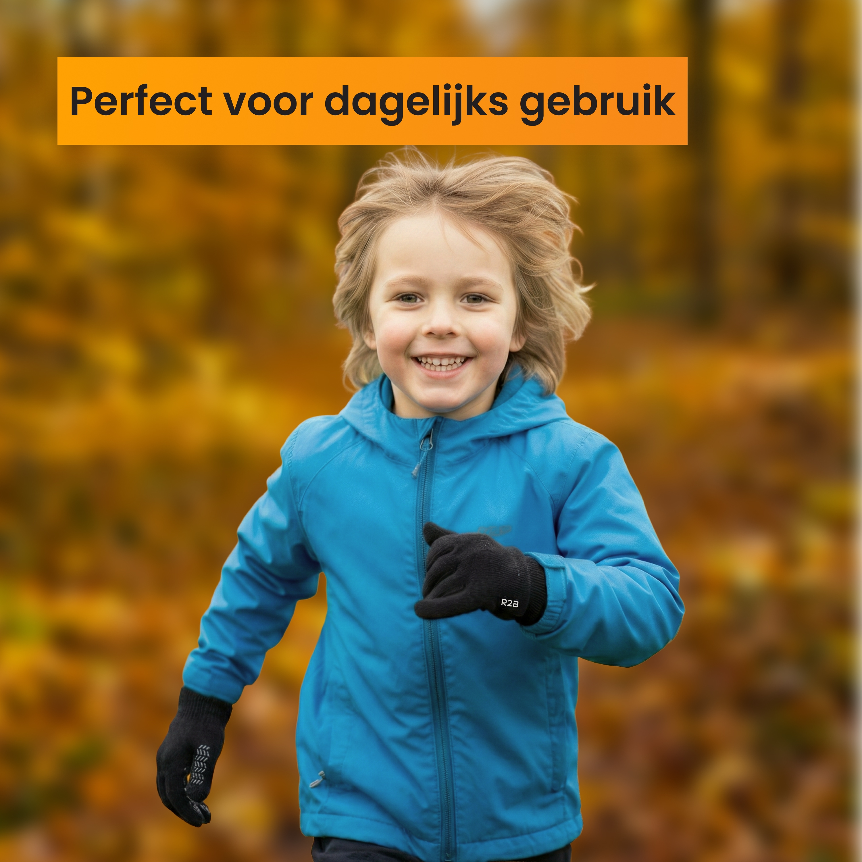 A smiling boy in a blue jacket and black gloves runs outdoors in autumn.