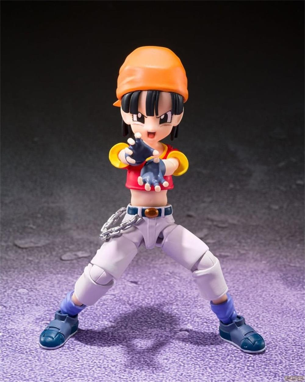 Una figura de acción con sombrero naranja, top rojo y pantalones blancos.
