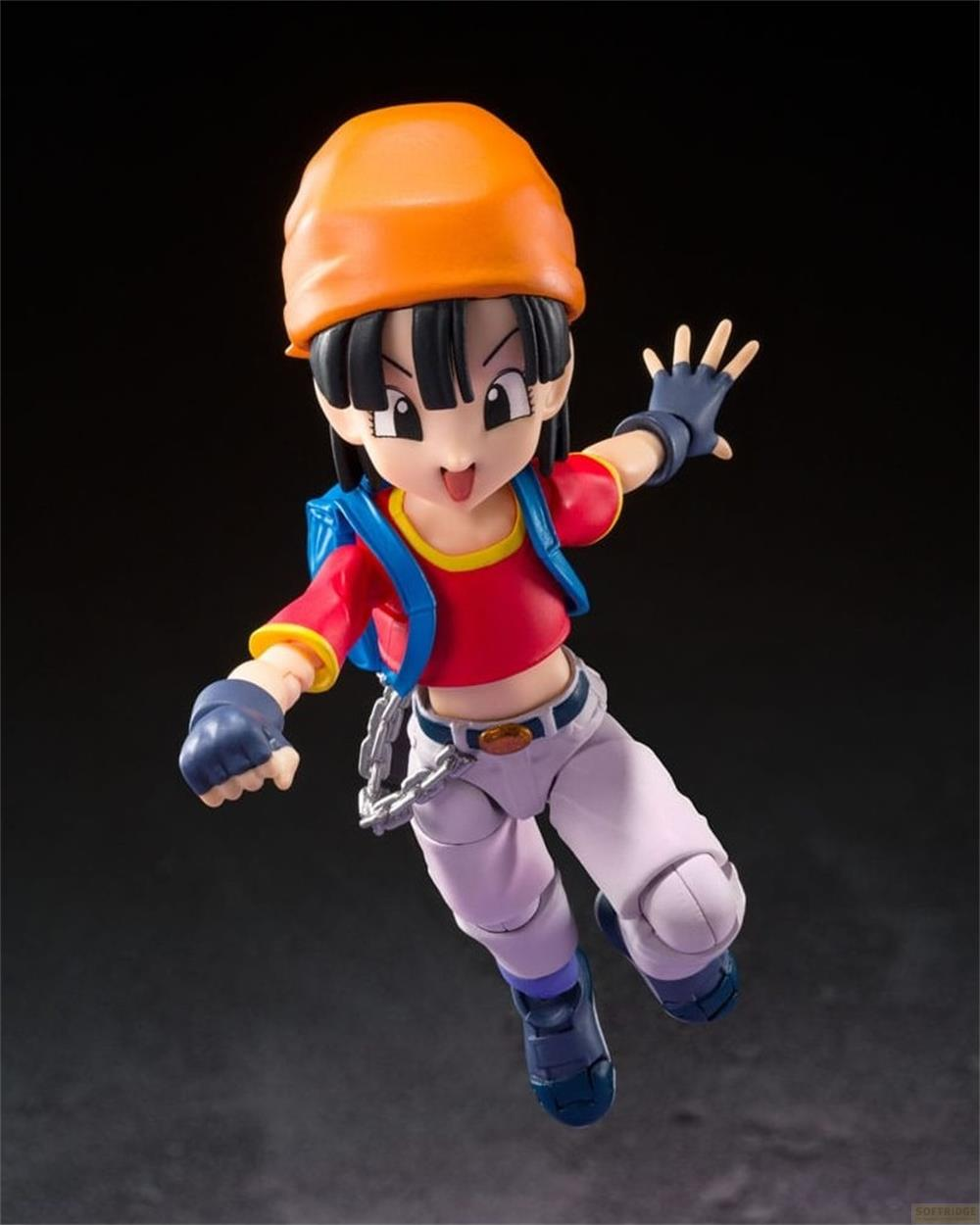 Una figura con sombrero naranja, top rojo y chaleco azul salta.