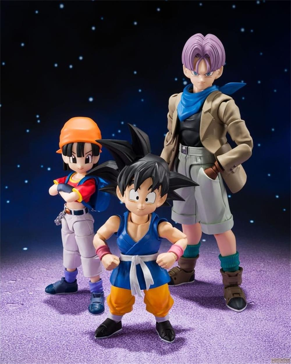 Tres figuras de acción de Dragon Ball ante un cielo estrellado. Pan a la izquierda, Goku al centro, Trunks a la derecha.