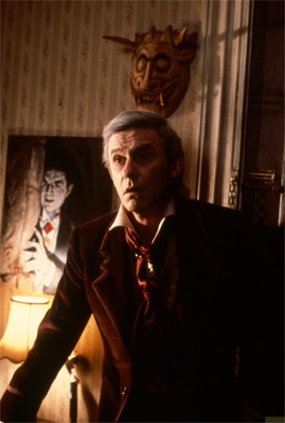 Un homme aux cheveux gris porte un costume et une cravate rouges.