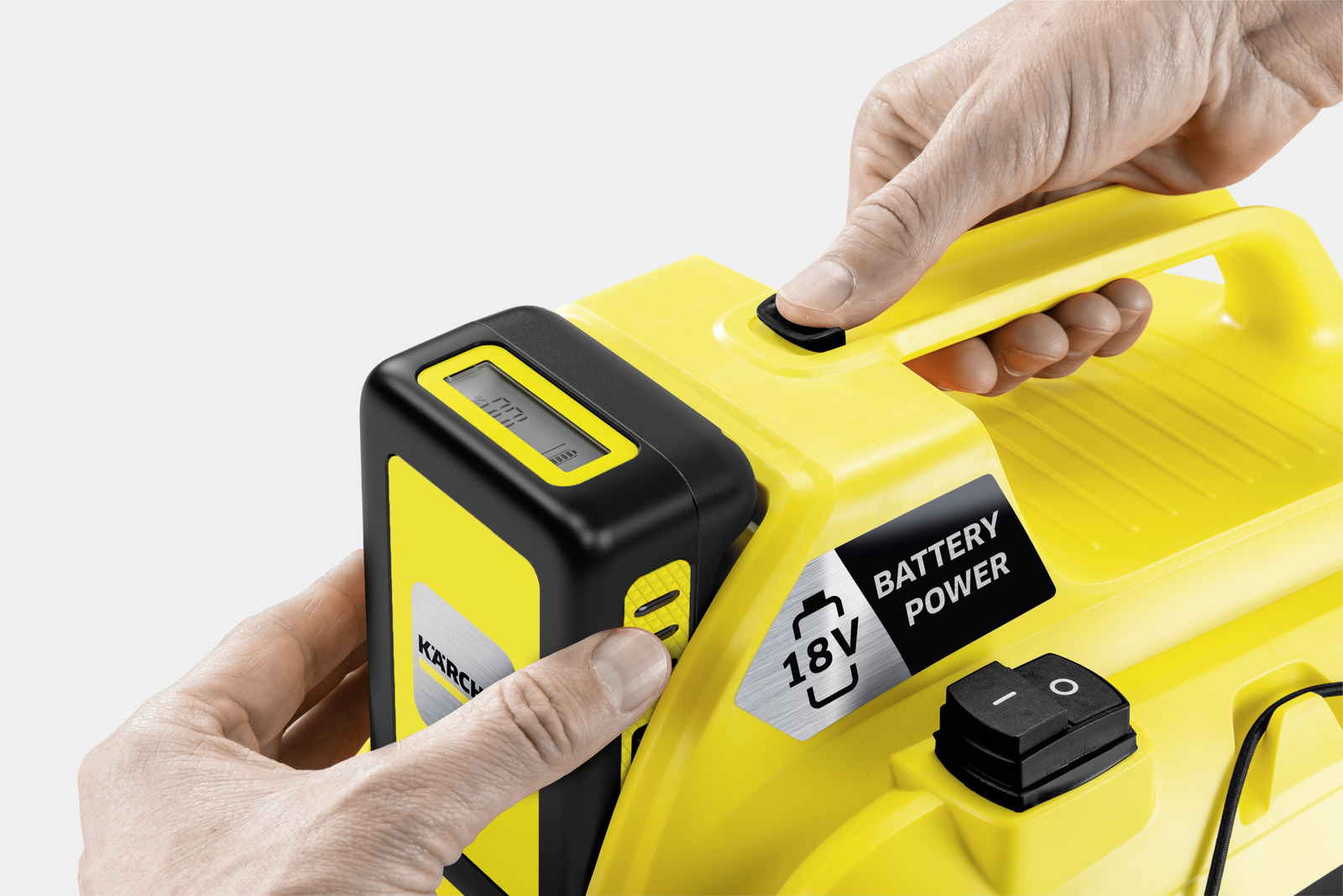 Yellow device with black display and controls. Hands operating buttons.