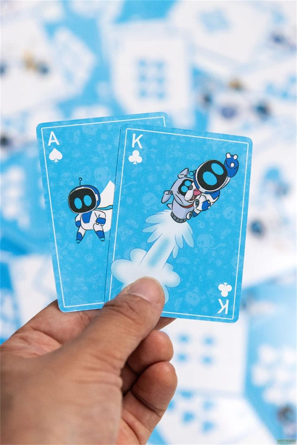 Eine Hand hält Spielkarten mit blauen Roboterfiguren. Ass und König.