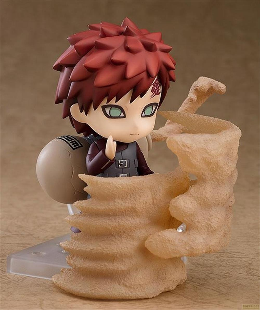 Una figura chibi anime con capelli rossi e una zucca sulla schiena, circondata dalla sabbia.