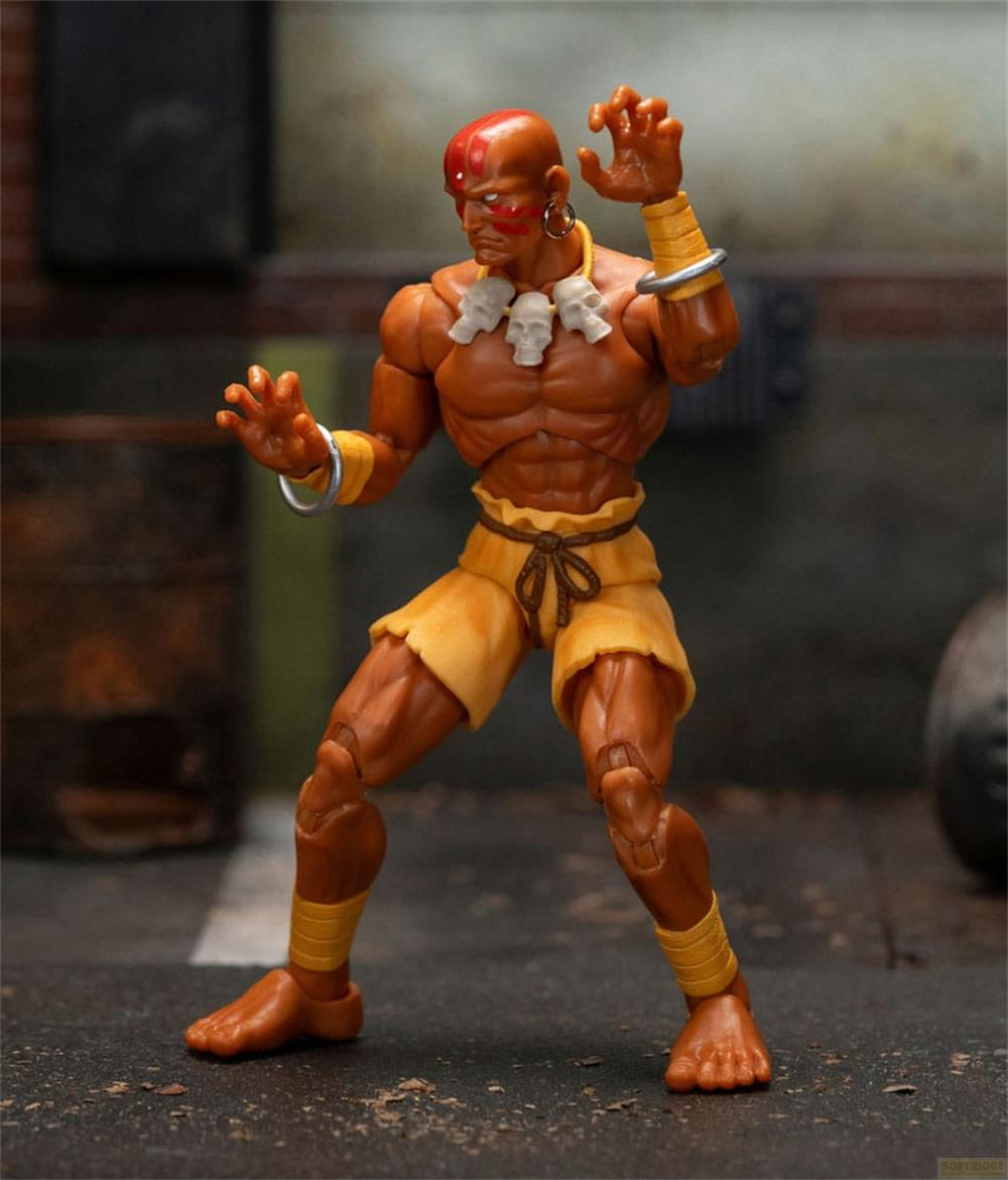Una action figure di un uomo con pelle arancione e pantaloncini gialli in posa da combattimento.
