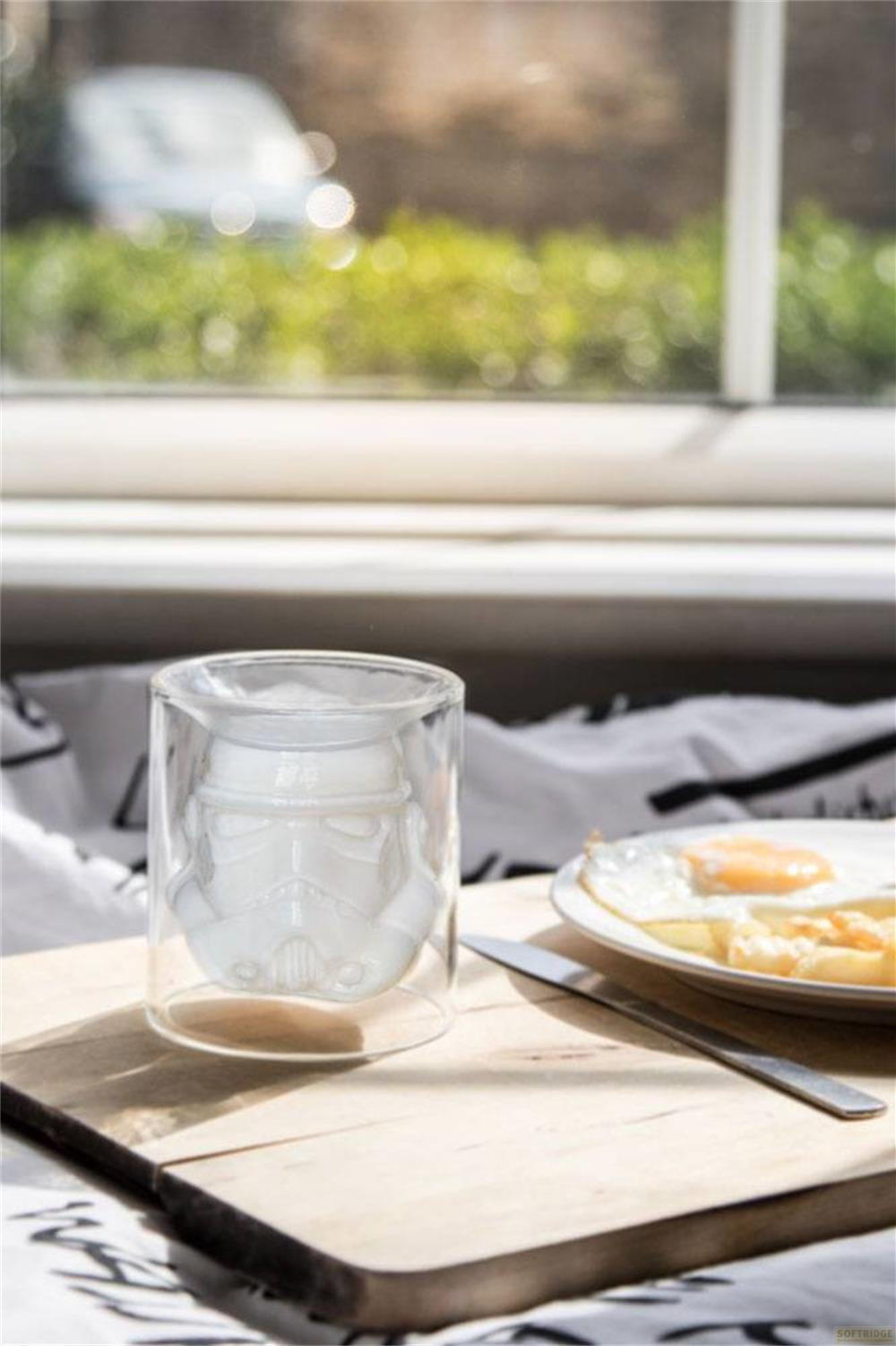 Ein Glas mit Stormtrooper-Helm-Design neben einem Teller mit Spiegelei.