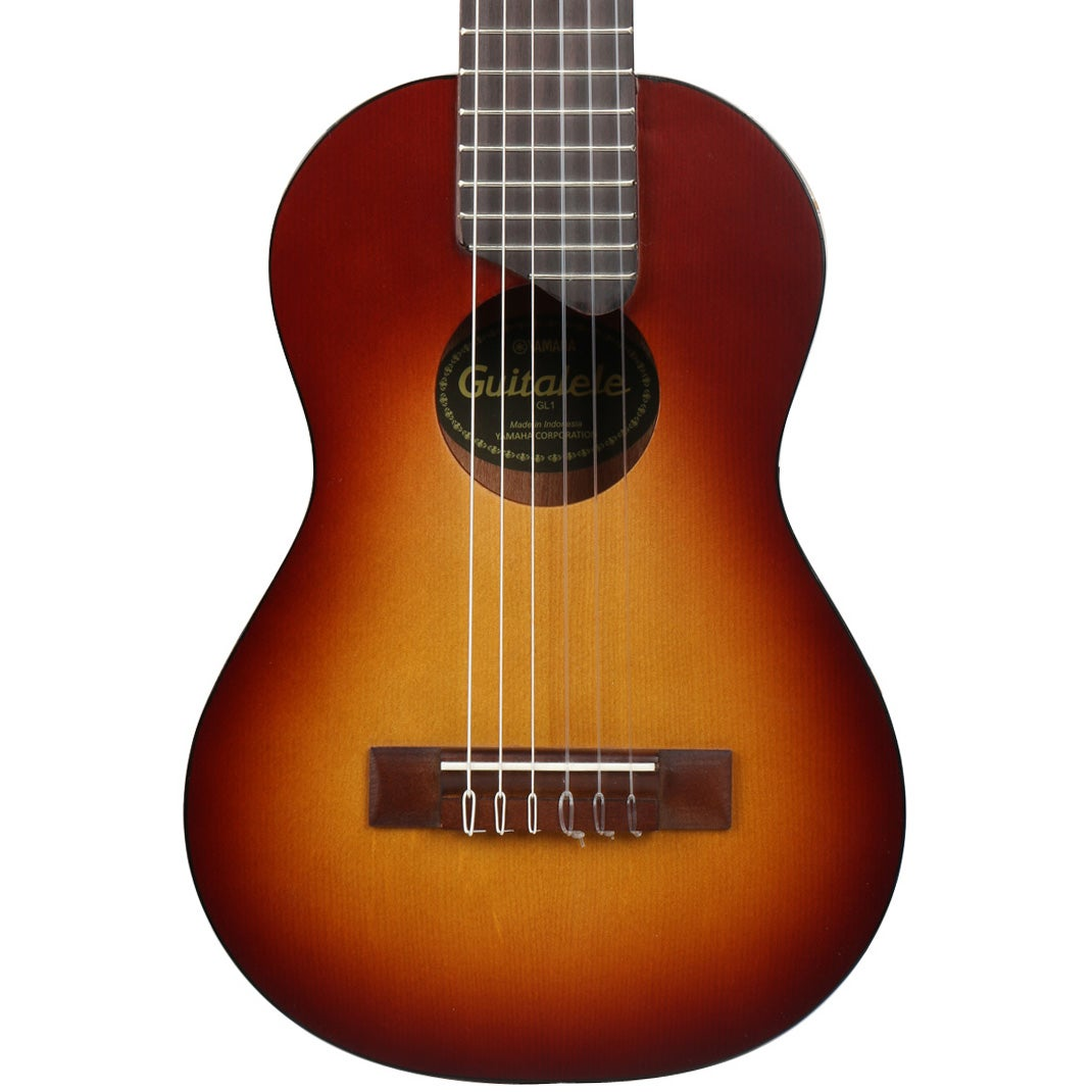 Brązowo-pomarańczowa gitara akustyczna z sześcioma strunami i ciemną podstrunnicą.