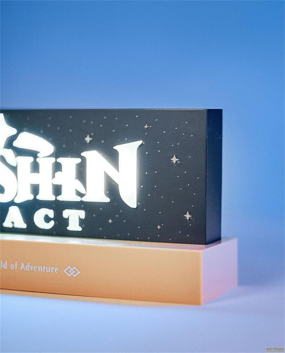 Ein beleuchtetes Schild mit den Worten "SHIN ACT" auf einem beigefarbenen Sockel vor blauem Hintergrund.