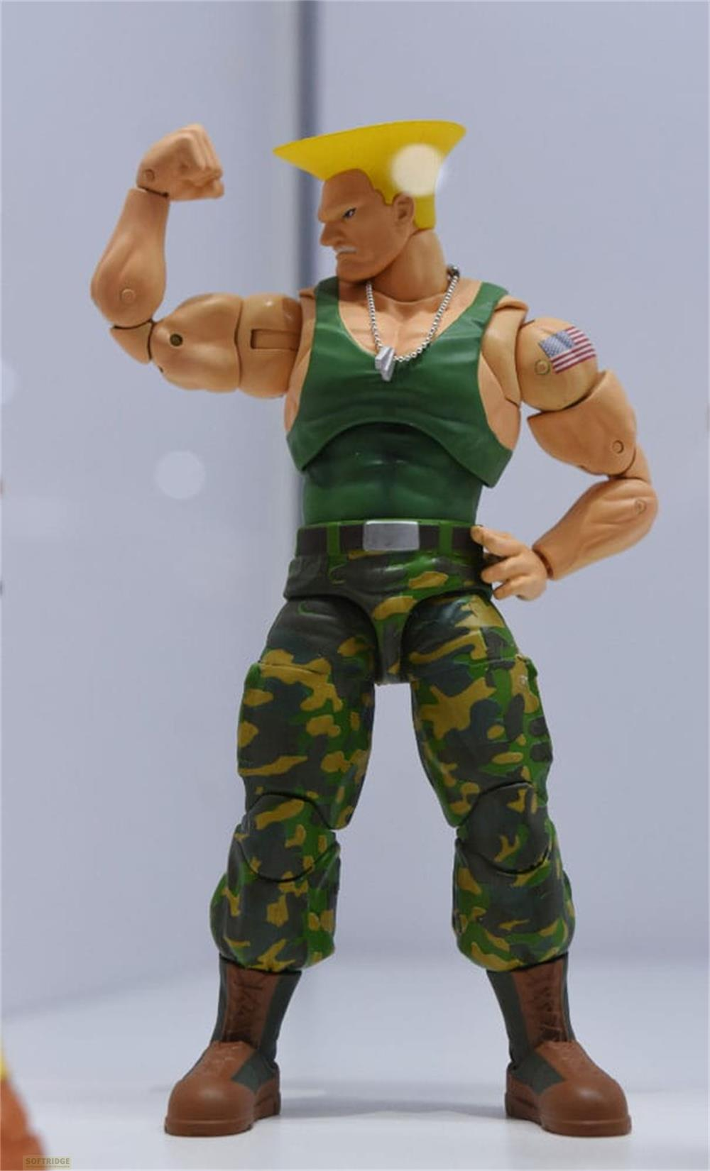 Eine Actionfigur mit gelben Haaren, grüner Weste, Camouflage-Hose und braunen Stiefeln.