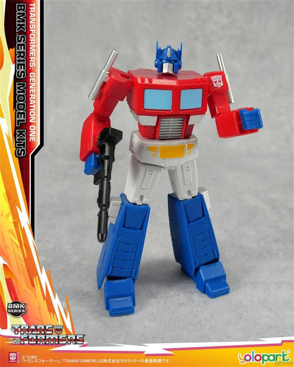 Un robot jouet rouge, blanc et bleu, Optimus Prime, tenant une arme.